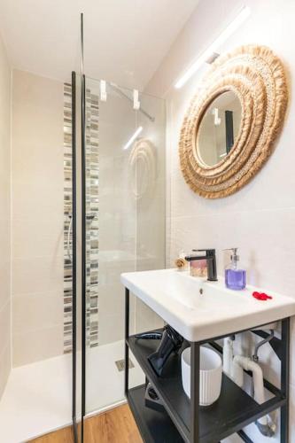 une salle de bain avec un lavabo et une douche avec un miroir dans l'établissement Tapualiki studio cosy tout confort, à Cannes