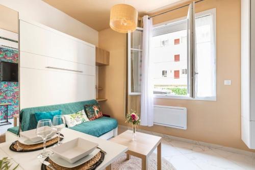 un salon avec un canapé vert et une table dans l'établissement Tapualiki studio cosy tout confort, à Cannes