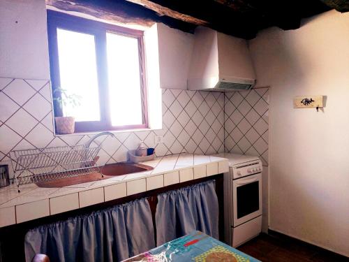 una pequeña cocina con fregadero y ventana en Casa Venus, en Sabinosa