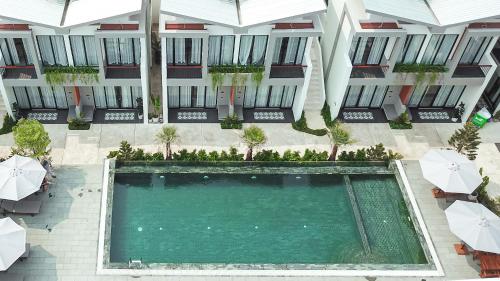 an overhead view of a swimming pool in a building with umbrellas at Emerald Residence Kampot in Kampot