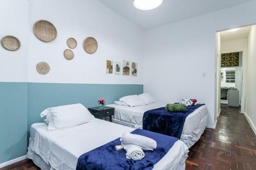 twee bedden in een kamer met blauwe en witte muren bij Princesa de Copacabana - Praia e Exclusividade! in Rio de Janeiro