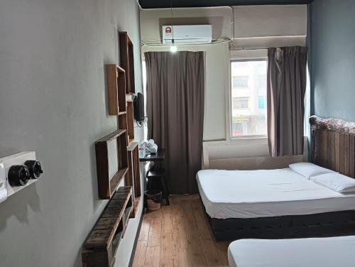 een hotelkamer met 2 bedden en een raam bij OYO 90863 Hi Inn 2 in Sibu