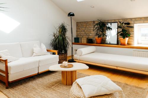 ein Wohnzimmer mit 2 weißen Sofas und einem Tisch in der Unterkunft White Loft in the Riga City Center in Riga