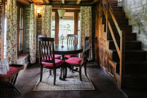 a dining room with a table and chairs and stairs at Nine Furlongs, Binsar Wildlife Sanctuary in Almora