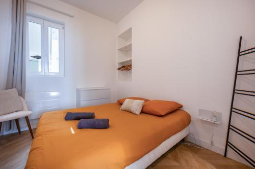a bedroom with a bed with two pillows on it at La Perle Citadine En Hyper Centre in La Rochelle
