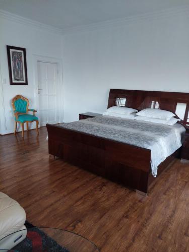 - une chambre avec un grand lit et du parquet dans l'établissement 46 Charles Street, Grootfontein Country Estate.Pretoria East, à Tierpoort