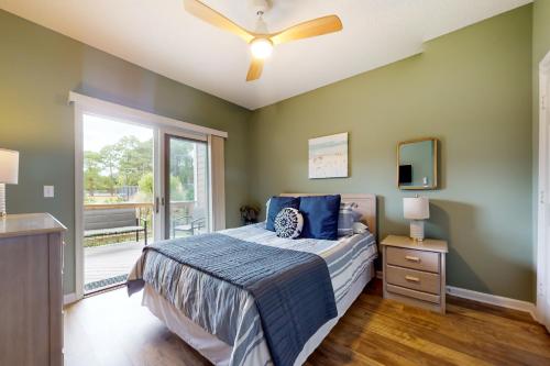 a bedroom with a bed and a ceiling fan at Sand Still at Corolla Light in Corolla