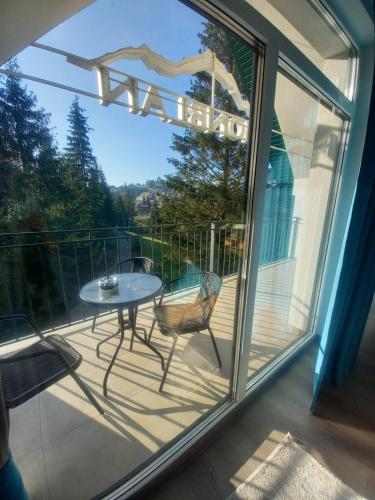 a patio with a table and chairs on a balcony at Отель MONBLAN in Yablunytsya