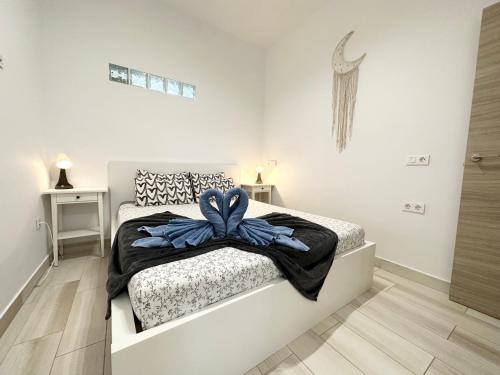 a bedroom with a bed with a blue bow on it at Cotillo Sol en el centro del Cotillo, 1 minuto de la playa, 2 habitaciones, terraza y WIFI in Cotillo