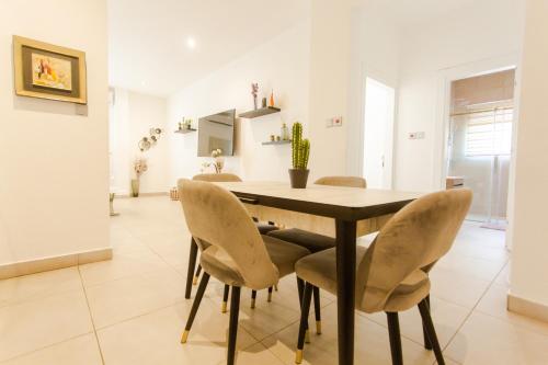 Un comedor con mesa y sillas en Accra Luxury Apartments @ Pine Court, en Cantonments