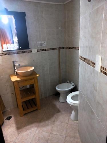 a bathroom with a sink and a toilet at San Remo World Hotel in San Clemente del Tuyú