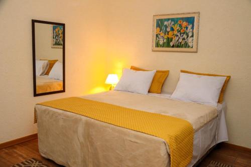 a bedroom with a large bed with two pillows at HOTEL ESTÂNCIA - ESTACIONAMENTO GRATUITO ROTATIVO - Vagas Limitadas in Poços de Caldas