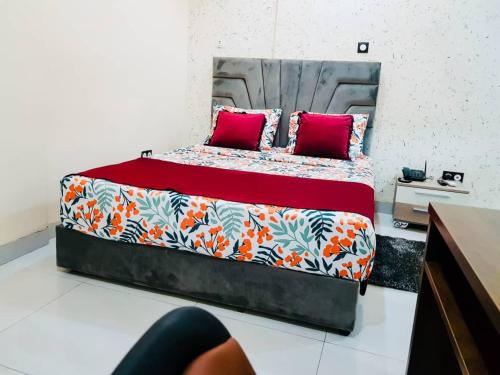 a bedroom with a large bed with red pillows at Complexe Hôtelier AnD in Ouagadougou