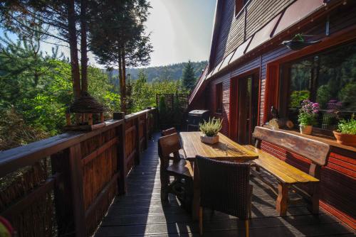 una terraza de madera con mesa y sillas en una casa en Ski House Szczyrk - Solisko, en Szczyrk