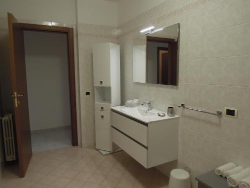 ein Badezimmer mit einem weißen Waschbecken und einem Spiegel in der Unterkunft Casa di RO' in Taranto