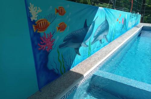 a swimming pool with a mural of fish at Hotel & Hostal Mayflower in Puerto Escondido