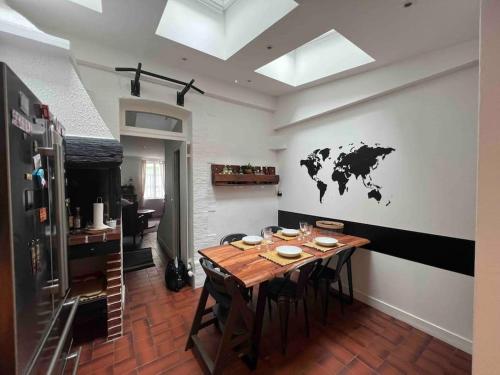 a dining room with a table and a world map on the wall at Ravissante maison de pêcheurs Trouville proche centre et gare in Trouville-sur-Mer
