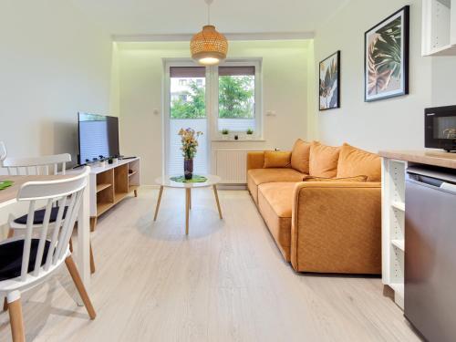 a living room with a couch and a table at Tricity Retreat Apartments with Parking - by Rentujemy in Straszyn