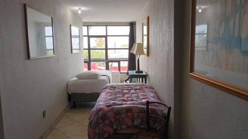 Kleines Zimmer mit einem Bett und einem Fenster in der Unterkunft Panoramic Penthouse Downtown (Free Parking) in Tijuana