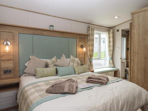 a bedroom with a large bed with two towels on it at Hazel Lodge in Newton Abbot