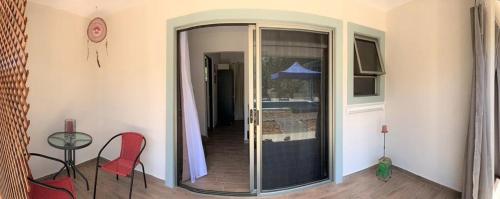 a room with a glass door with a table and chairs at Lovely studio-apartment near the beach in Uvita