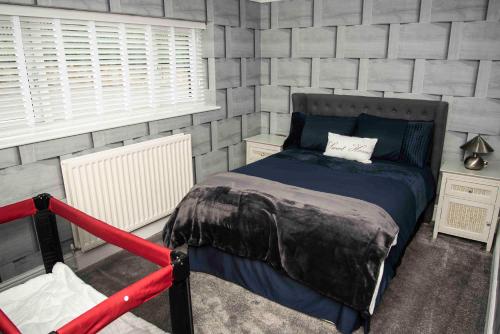 a bedroom with a bed in a gray wall at Little Retreat in Woodhouse