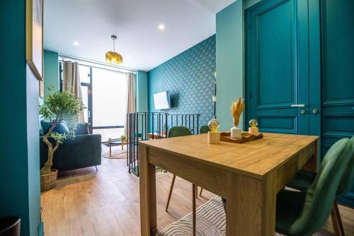 une salle à manger avec une table en bois et des murs bleus dans l'établissement Beautiful Apartment close to Eiffel Tower, à Paris