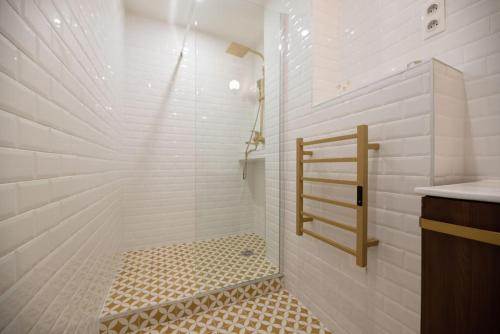 La salle de bains est pourvue d'une douche et de carrelage. dans l'établissement Beautiful Apartment close to Eiffel Tower, à Paris