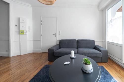 sala de estar con sofá y mesa en Le Girard - Appartement centre ville - Parking, en Vichy