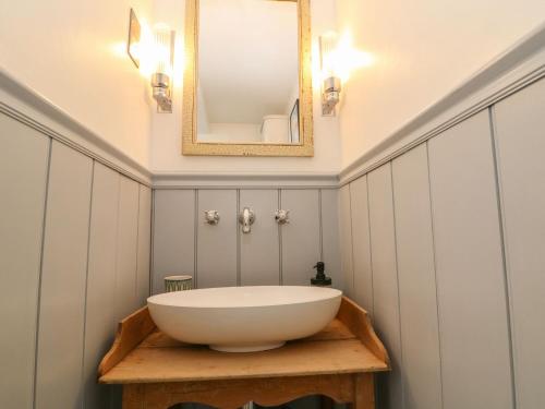 a bathroom with a white sink and a mirror at Butterrow Gate in Stroud