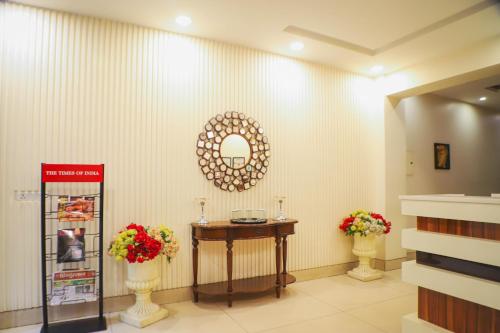 a room with a table and flowers on the wall at Hotel Central Palace in Dehradun