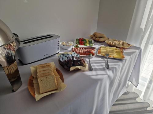 a white table with sandwiches and other foods on it at Elixír Panzió in Nyírbátor