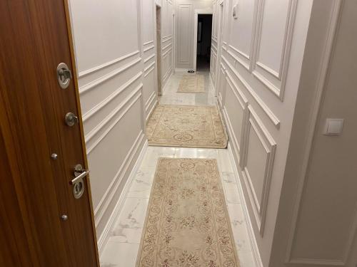 korytarz z drzwiami i dywanem na podłodze w obiekcie Luxury Flat / Lux Daire Cizre w mieście Jesıret ibn Omar