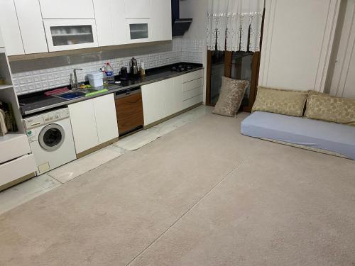 eine Küche mit weißen Schränken und einem Sofa in einem Zimmer in der Unterkunft Luxury Flat / Lux Daire Cizre in Jesıret ibn Omar