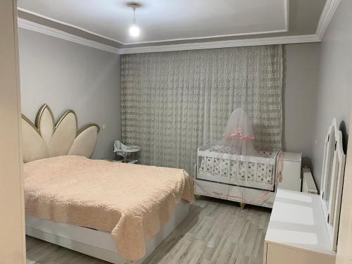 1 dormitorio con 1 cama y 1 cuna en Luxury Flat / Lux Daire Cizre, en Jesıret ibn Omar