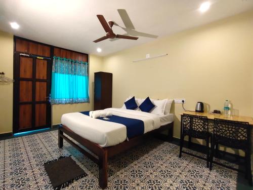 um quarto com uma cama e uma ventoinha de tecto em PV Cottages Serenity Beach em Pondicherry