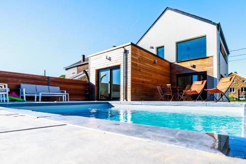 una casa con piscina frente a una casa en L'Ardenne de Fidéline, en Tenneville