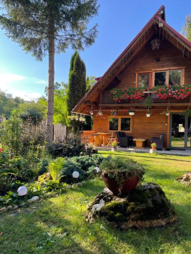a log cabin with a garden in front of it at Cabana Mistic in Bran