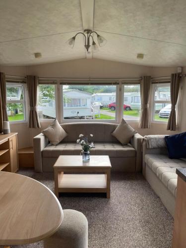 a living room with a couch and a table at Holiday home at Parkdean Cherry Tree Holiday Park 627 in Great Yarmouth