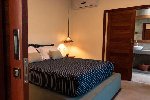 a bedroom with a bed and a bathroom at Vila de Charme in São Miguel do Gostoso
