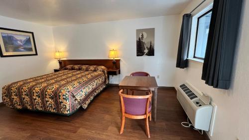 1 dormitorio con 1 cama y escritorio con ordenador en Pine Cone Motel, en Willits