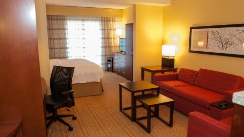 a hotel room with a bed and a living room at Courtyard by Marriott Pittsburgh North/Cranberry Woods in Cranberry Township