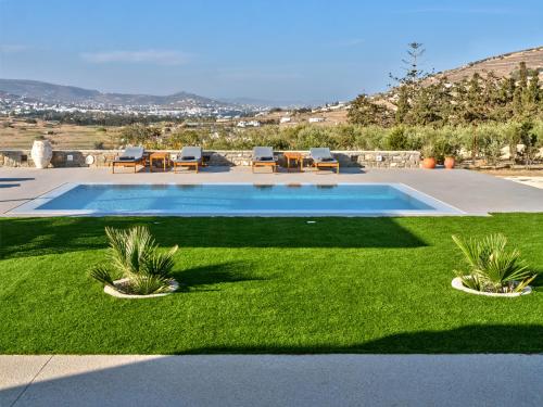 een zwembad in een tuin met groen gras bij Villa Leo - Unique & Calm in Kampos Paros
