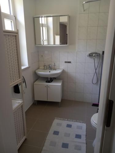 a white bathroom with a sink and a mirror at Appartement für 4 Personen in Nürnberg in Nuremberg
