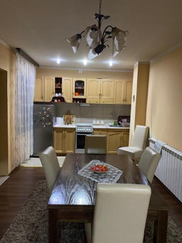 - une cuisine avec une table en bois et des chaises blanches dans l'établissement Nena, à Veliko Gradište