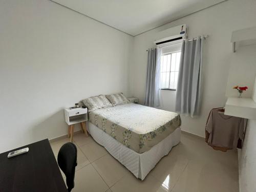 een witte slaapkamer met een bed en een raam bij Apartamento com garagem no maior setor comercial de BV in Boa Vista