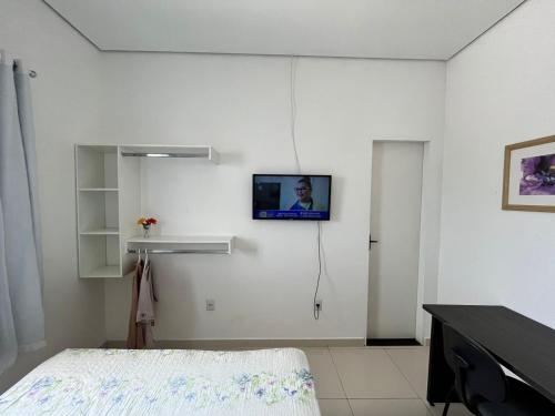 een witte kamer met een tv aan de muur bij Apartamento com garagem no maior setor comercial de BV in Boa Vista