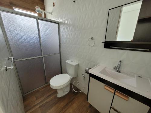 een badkamer met een toilet, een douche en een wastafel bij Apartamento com garagem no maior setor comercial de BV in Boa Vista