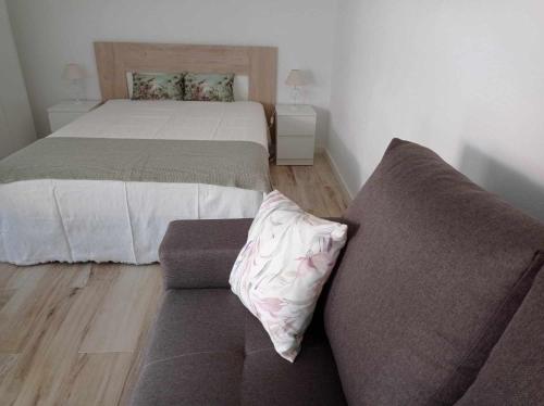 a living room with a bed and a couch at Casinha2 in Amieira