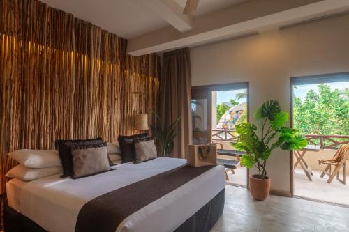 a bedroom with a large bed and a balcony at Hotel Arena in Holbox Island